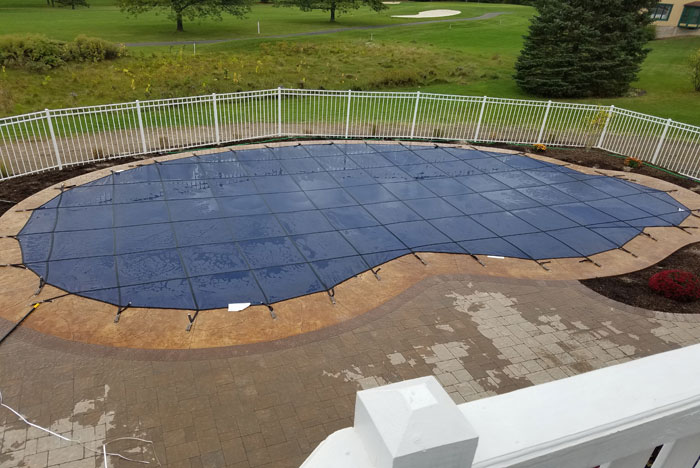 Pool opening and closing services. An inground pool with a winter cover